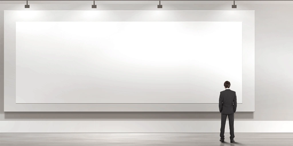 man in suit standing in front of large white canvas on wall