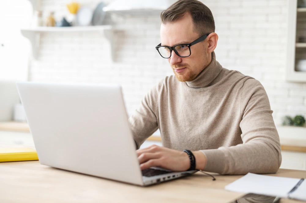 smart man in glasses using an optimization tool on his laptop